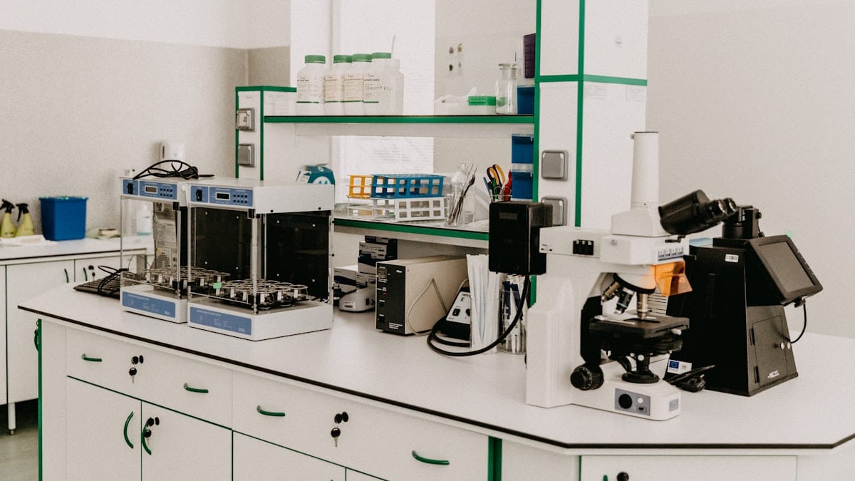 A laboratory workbench with a microscope and analytical equipment in a bright room