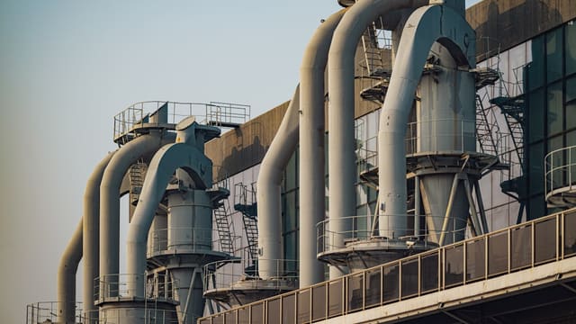 a row of pipes on a building with a sky background