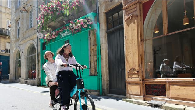 a woman riding a bike next to a woman in a white shirt