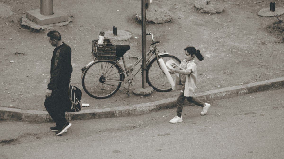 Man and girl with bicycle on pavement