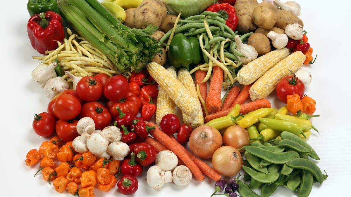 a pile of different types of vegetables on a white surface