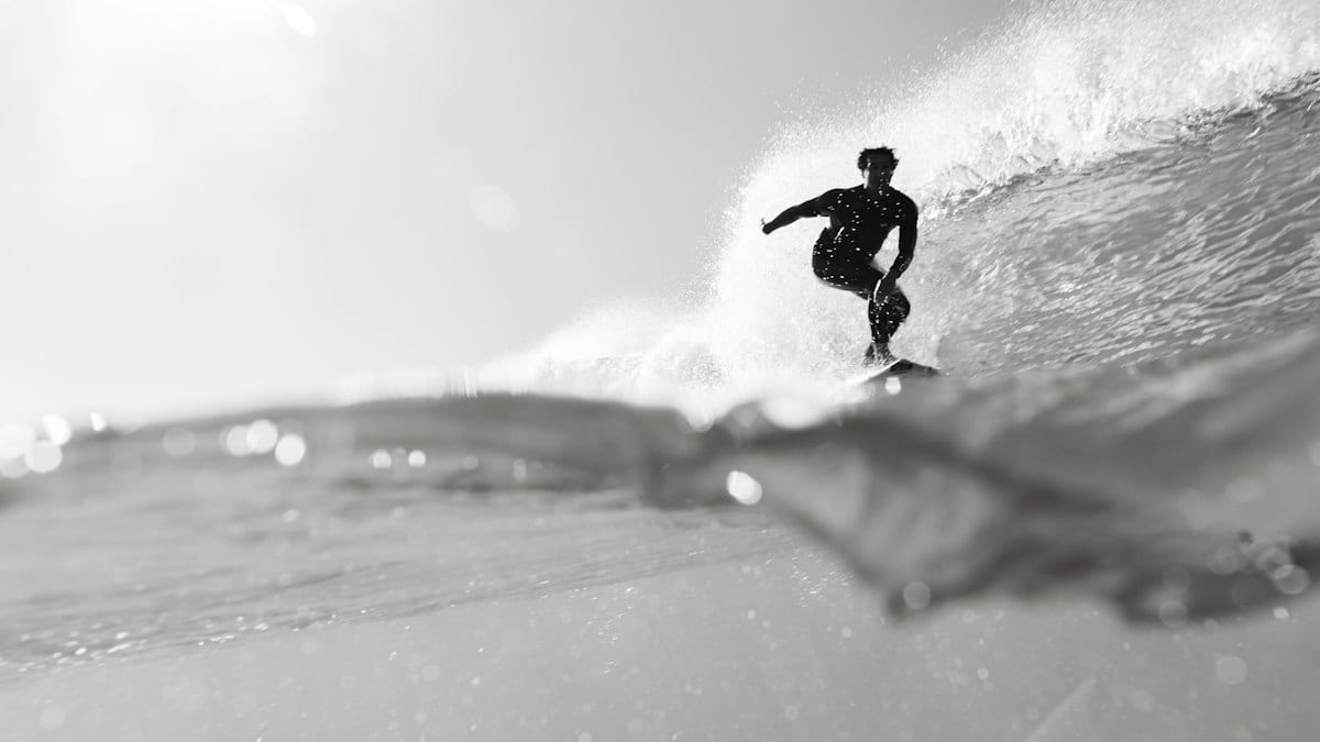 a man riding a wave on top of a surfboard