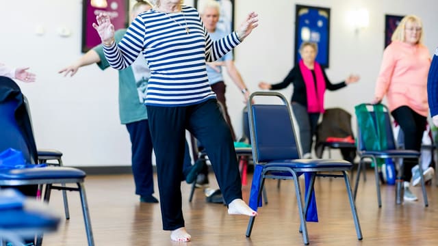 a group of older women dancing in a room