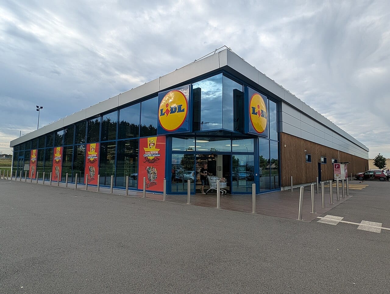 Devanture vitrée d'un magasin Lidl, logo jaune et rouge au-dessus de l'entrée.
