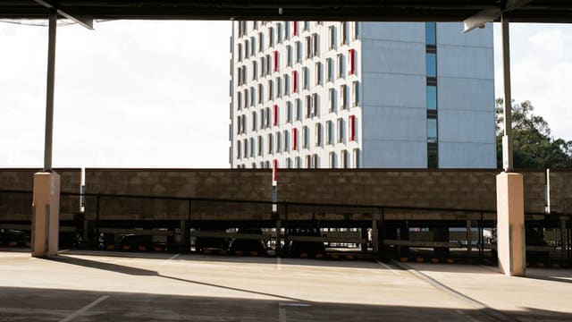 Urban parking lot overlooking a contemporary building with red windows