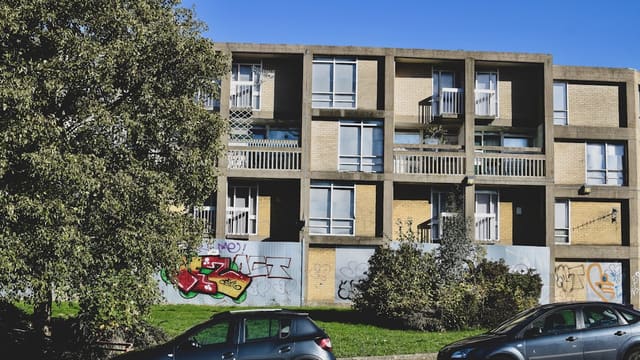 two cars parked in front of a building with graffiti on it