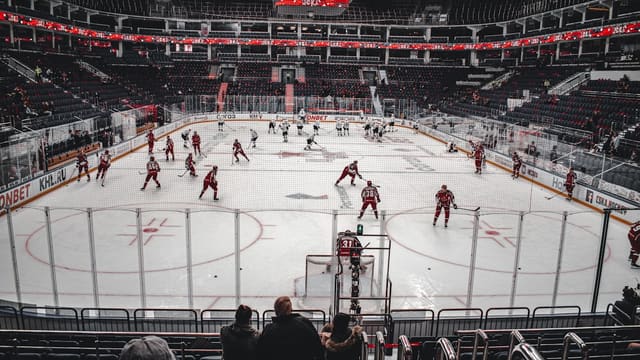 people playing ice hockey on stadium during daytime