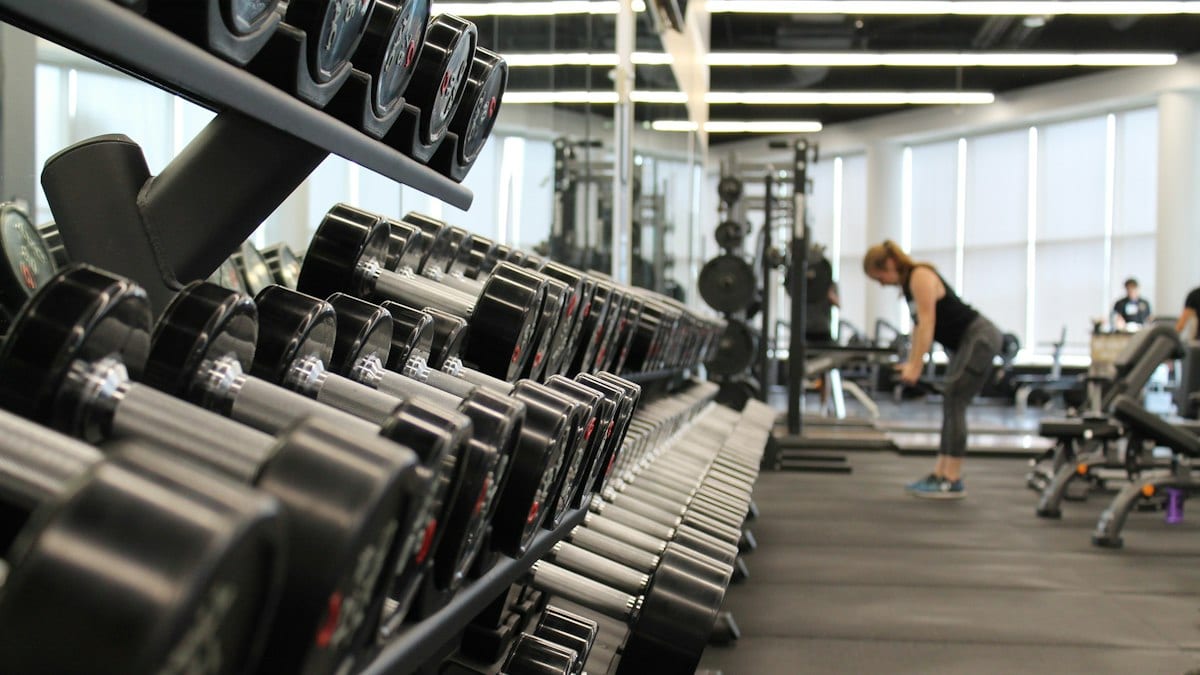 woman standing surrounded by exercise equipment
