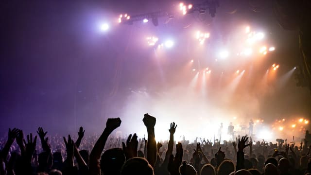 crowd facing lighted stage
