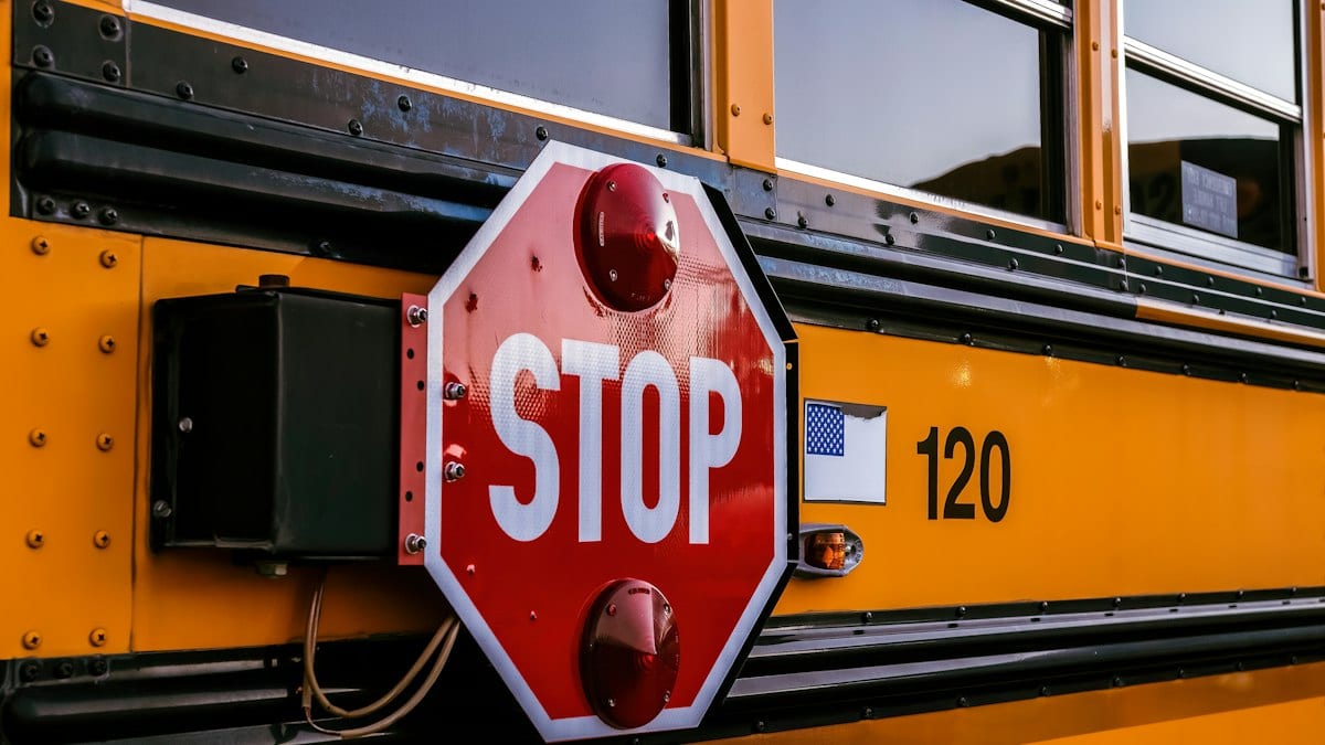a stop sign attached to the side of a school bus